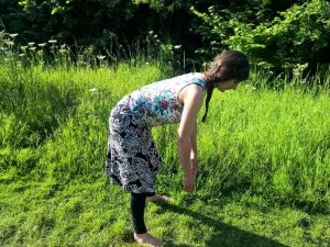 Bending down at the hips with the back straigh